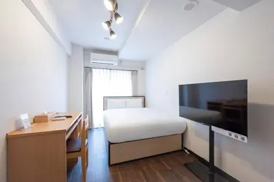 a bedroom with a bed and a desk and a television at Elm\u9ad8\u7530\u99ac\u5834 in Tokyo