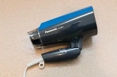 a hair dryer with a hair brush in a holder at Nakano Apartment hotel in Tokyo