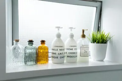 a shelf with several bottles on a window sill at Nakano Apartment hotel in Tokyo