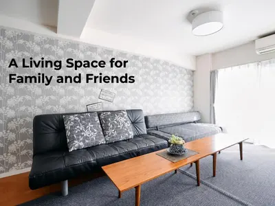a living room with a black couch and a table at Nakano Apartment hotel in Tokyo