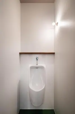 a urinal in a bathroom with a light on the wall at Mochida Hall 1F / Vacation STAY 80337 in Tokyo