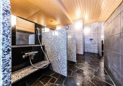 a bathroom with two stalls with a shower at APA Hotel Higashi Shinjuku Kabukicho Tower in Tokyo