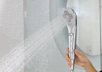 a person holding a shower brush in front of a window at APA Hotel Higashi Shinjuku Kabukicho Tower in Tokyo