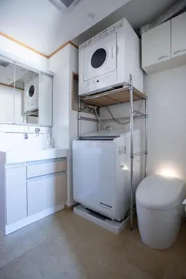 a bathroom with a washer and dryer and a toilet at NIYS apartments 04 type in Tokyo
