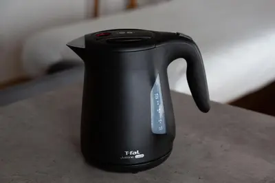 a black tea kettle sitting on a table at NIYS apartments 04 type in Tokyo