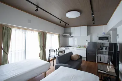 a room with a bed and a kitchen with a couch at NIYS apartments 04 type in Tokyo