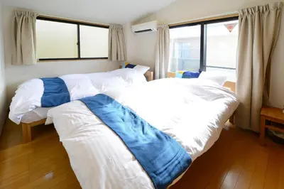 two beds in a room with two windows at Sumida-ku - House / Vacation STAY 80342 in Tokyo