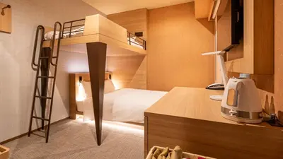 a small room with a bunk bed in a room at Galois Hotel Shinokubo in Tokyo