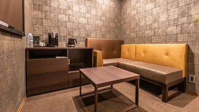 a waiting room with a bench and a table at Galois Hotel Shinokubo in Tokyo