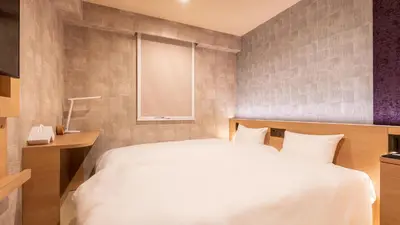 a bedroom with a white bed and a window at Galois Hotel Shinokubo in Tokyo