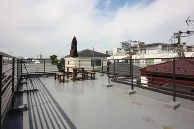 a rooftop deck with tables and an umbrella at \u58a8\u75304\u4e01\u76ee in Tokyo