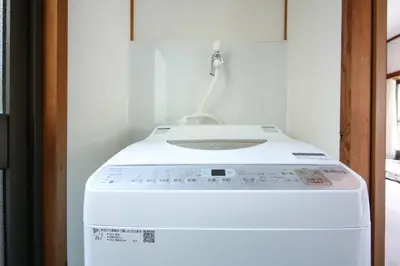 a white washing machine sitting in a room at \u58a8\u75304\u4e01\u76ee in Tokyo