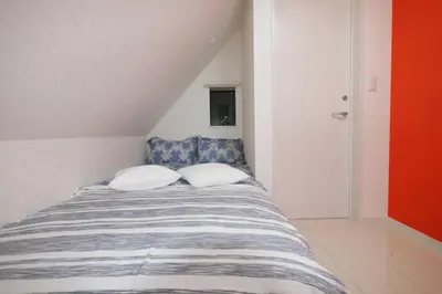 a bedroom with a bed with two pillows on it at \u30a2\u30f3\u30c9\u30b9\u30c6\u30a4\u9ad8\u78022\u4e01\u76ee in Tokyo