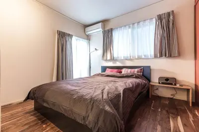a bedroom with a bed and a window at \u30a2\u30f3\u30c9\u30b9\u30c6\u30a4\u767e\u4eba\u753a2\u4e01\u76eeA in Tokyo