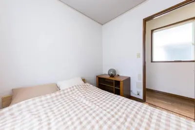a bedroom with a bed and a window at \u30a2\u30f3\u30c9\u30b9\u30c6\u30a4\u767e\u4eba\u753a2\u4e01\u76eeA in Tokyo