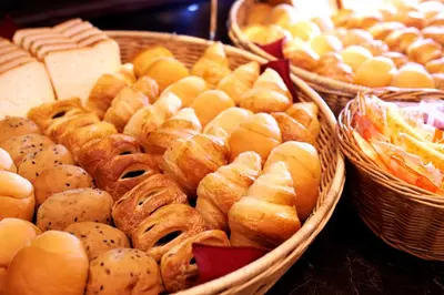 a bunch of baskets filled with different types of bread at Super Hotel JR Ueno Iriyaguchi in Tokyo