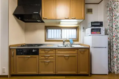 a kitchen with a sink and a white refrigerator at \u30a2\u30f3\u30c9\u30b9\u30c6\u30a4\u6edd\u91ce\u5ddd3\u4e01\u76ee in Tokyo