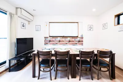 a dining room with a table and chairs and a television at \u30a2\u30f3\u30c9\u30b9\u30c6\u30a4\u672c\u753a5\u4e01\u76ee in Tokyo
