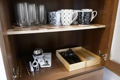 a wooden cabinet with utensils on a shelf at \u30a2\u30f3\u30c9\u30b9\u30c6\u30a4\u672c\u753a5\u4e01\u76ee in Tokyo