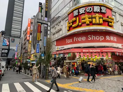 a busy city street with people crossing a crosswalk at \u30a2\u30f3\u30c9\u30b9\u30c6\u30a4\u672c\u753a5\u4e01\u76ee in Tokyo