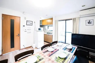 a living room with a dining table and a kitchen at \u30a2\u30f3\u30c9\u30b9\u30c6\u30a4\u672c\u753a5\u4e01\u76ee in Tokyo