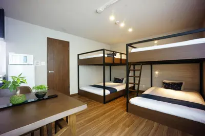 a bedroom with two bunk beds and a desk at RoNa Hotel in Tokyo