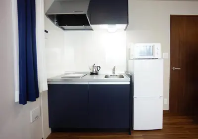 a small kitchen with a sink and a refrigerator at RoNa Hotel in Tokyo