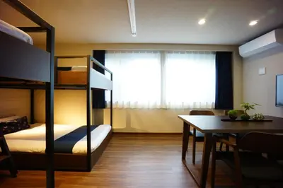a bedroom with a bunk bed and a dining room with a table at RoNa Hotel in Tokyo