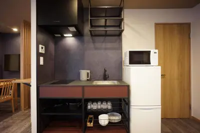 a kitchen with a white refrigerator and a sink at WIRES HOTEL James zaka in Tokyo