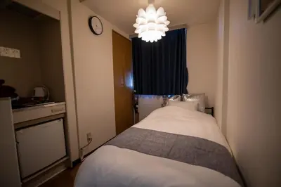 a bedroom with a bed and a chandelier at Vail sta Takenotsuka in Tokyo