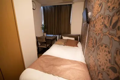 a hotel room with two beds and a desk at Vail sta Takenotsuka in Tokyo