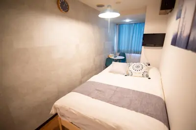 a small bedroom with a bed in a room at Vail sta Takenotsuka in Tokyo