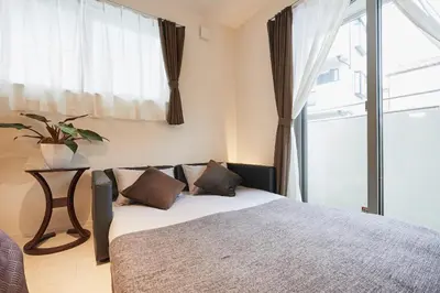a bedroom with a bed and a large window at Frieden Haus in Tokyo