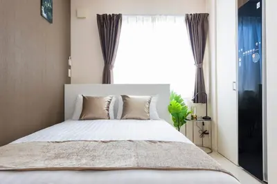 a bedroom with a bed with a large window at Frieden Haus in Tokyo