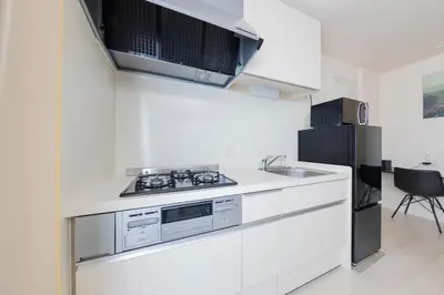 a white kitchen with a stove and a refrigerator at Frieden Haus in Tokyo