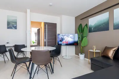 a living room with a table and chairs and a tv at Frieden Haus in Tokyo