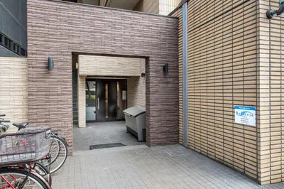 a bike parked next to a brick wall with a door at NC Square Shinjuku -All Suite Residence- in Tokyo