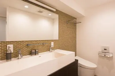 a bathroom with a white sink and a mirror at NC Square Shinjuku -All Suite Residence- in Tokyo