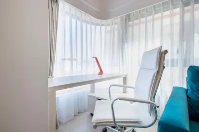 a white chair in a room with a desk and a window at NC Square Shinjuku -All Suite Residence- in Tokyo