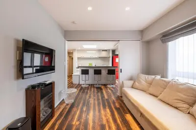 a living room with a couch and a flat screen tv at NC Square Shinjuku -All Suite Residence- in Tokyo