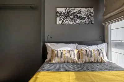 a bedroom with a bed with a yellow blanket at NC Square Shinjuku -All Suite Residence- in Tokyo