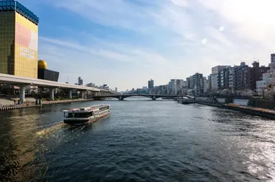 a boat traveling down a river in a city at Stay SAKURA Tokyo ASAKUSA ART DECO HOTEL in Tokyo