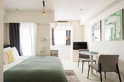 a hotel room with a bed and a table and chairs at Section L Ginza East in Tokyo