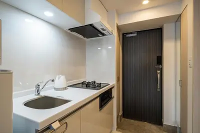 a kitchen with a sink and a black door at Section L Ginza East in Tokyo