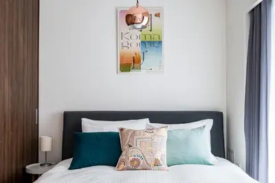 a bedroom with a bed with blue and green pillows at Section L Ginza East in Tokyo