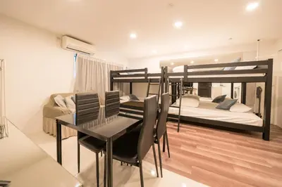 a room with two bunk beds and a table and chairs at Space F Yoyogi in Tokyo