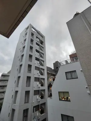 a tall white building next to two buildings at HIZ HOTEL Ginza in Tokyo