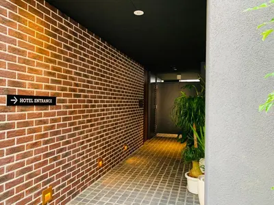 a hallway with a brick wall and two potted plants at HOTEL TABARD TOKYO in Tokyo