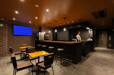 a man standing at a bar in a restaurant at HOTEL TABARD TOKYO in Tokyo