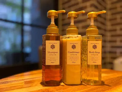 three bottles of soap sitting on a wooden table at HOTEL TABARD TOKYO in Tokyo